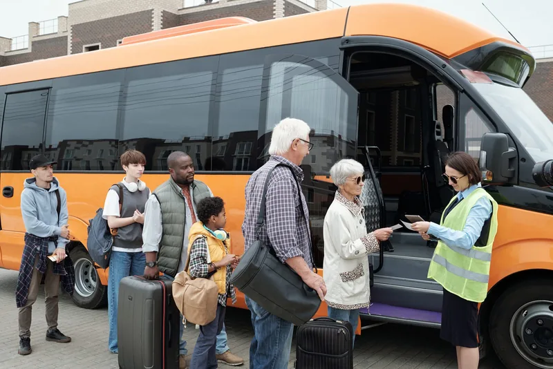 Fahrgäste melden sich vor dem Einstieg in einen Reisebus an