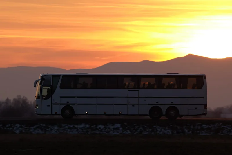 Silhouette eines Reisebusses vor einem Sonnenuntergang